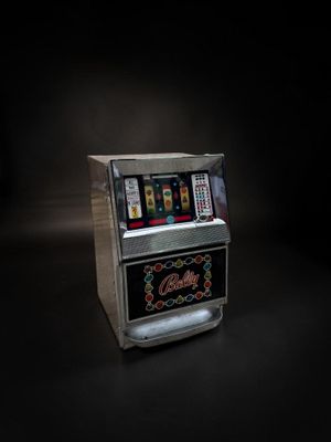 une vieille machine à sous posée sur une table dans une pièce sombre