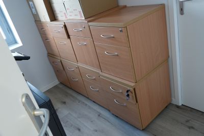 a tall wooden cabinet with drawers in a room