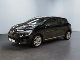 Une voiture noire est garée dans une pièce aux murs blancs.