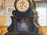 une horloge posée sur une table devant un miroir