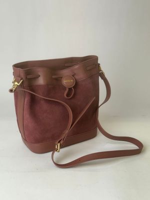 a brown purse with a strap on it sitting on a white surface