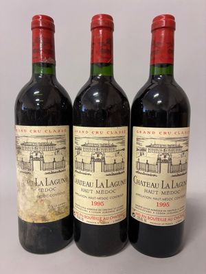 three bottles of red wine sitting next to each other on a table