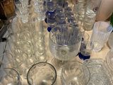 many glasses and vases sitting on a table