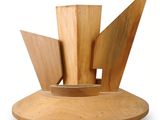 une sculpture en bois représentant un bateau, posée sur un socle en bois