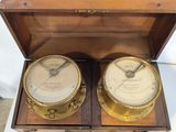 two clocks sitting in a wooden box on a table