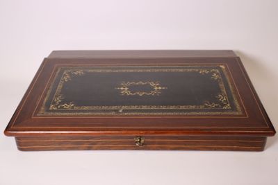 une vieille boîte en bois avec un couvercle en cuir noir et des bordures dorées