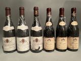 six bottles of wine are lined up in a row on a table