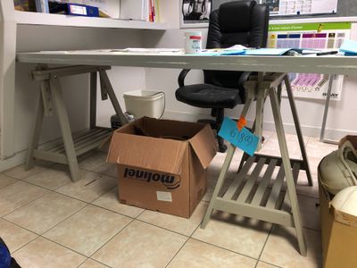 a desk with a chair and a box in front of it
