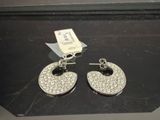 une paire de boucles d'oreilles argentées et en cristal exposées dans une vitrine