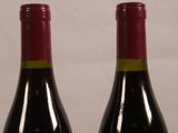 two bottles of wine sitting next to each other on a table