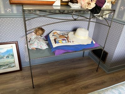 un petit enfant endormi sur un lit sur lequel est posé un chapeau