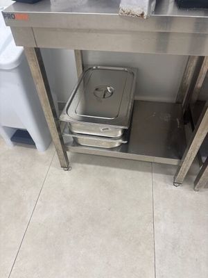 une table en acier inoxydable sur laquelle est posée une cuvette métallique