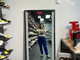 une femme en train de se prendre en photo dans un miroir dans un magasin de chaussures