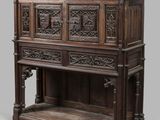 un vieux meuble en bois avec des sculptures sur le dessus et une étagère en dessous