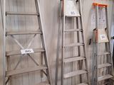 several ladders are lined up against a wall in a warehouse