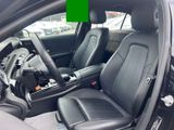 a picture of a car with black leather seats in a car showroom