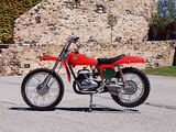 a red dirt bike parked in front of a stone building