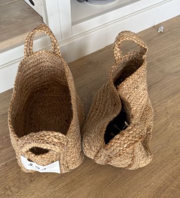 paire de paniers en jute naturel avec des anses, posés sur un sol en bois