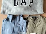 two pairs of sweaters with the word gap on them sitting on a cardboard box