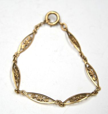 a close up of a gold bracelet on a white surface