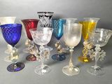 many different colored glass goblets and vases on the table