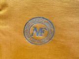 an image of a close up of a yellow shirt with a blue m logo on it