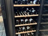 many bottles of wine on the shelves in the wine cooler