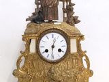 a gold clock with a statue on top of it