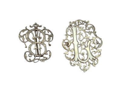 deux broches en argent ornées d'un monogramme au centre