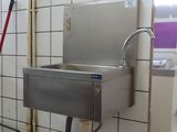 un évier en acier inoxydable dans le coin d'une salle de bains