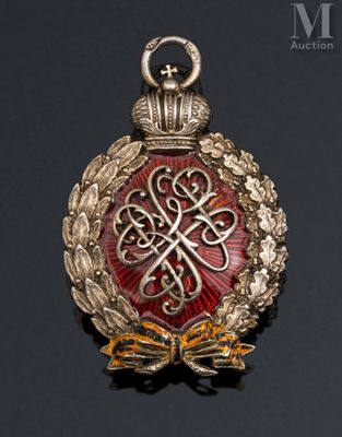 a close up of a gold and red broochle on a black surface