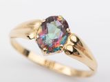 un gros plan d'une bague en or sertie d'une pierre aux couleurs de l'arc-en-ciel