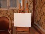 a chair and easel in the corner of a room