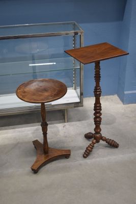 une petite table avec un plateau en bois et une vitrine en verre derrière