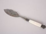 a silver spoon with a white handle sitting on a table