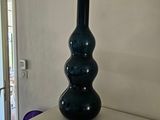un vase noir posé sur une table blanche