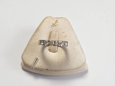 une bague en diamant posée sur une pierre blanche