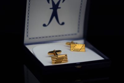 a box with two cufflinks and a ring in it
