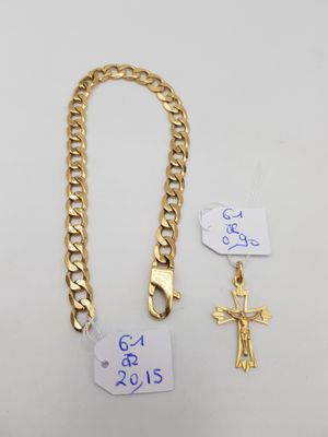 une chaîne en or ornée d'une croix, à côté de deux étiquettes