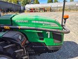 a green tractor that is parked in a lot