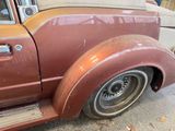 a rusted old car parked on the side of the road