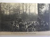 an old photo of a group of men and dogs in a wooded area