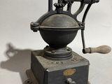 an old coffee grinder sitting on top of a wooden table