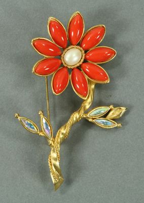 broche en forme de fleur dorée et rouge, ornée de perles et de feuilles