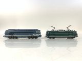 two trains that are sitting side by side on a white surface