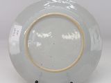a white plate with a gold rim on a white table