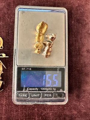 a gold nugget on a scale next to a gold nugget
