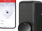 a close up of a cell phone next to a smart lock