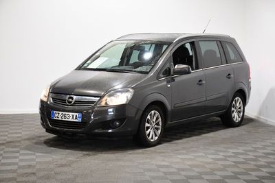 La petite camionnette grise est garée dans une pièce au sol carrelé.