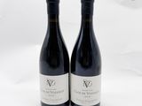 deux bouteilles de vin rouge posées l'une à côté de l'autre sur une surface blanche